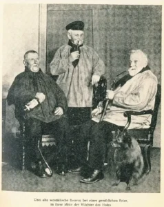 Drei alte westfälische Bauern bei einer gemütlichen Feier, in ihrer Mitte der Wolfsspitz als Wächter des Hofes (aus "Der Deutsche Spitz", Nr. 20, 1958)